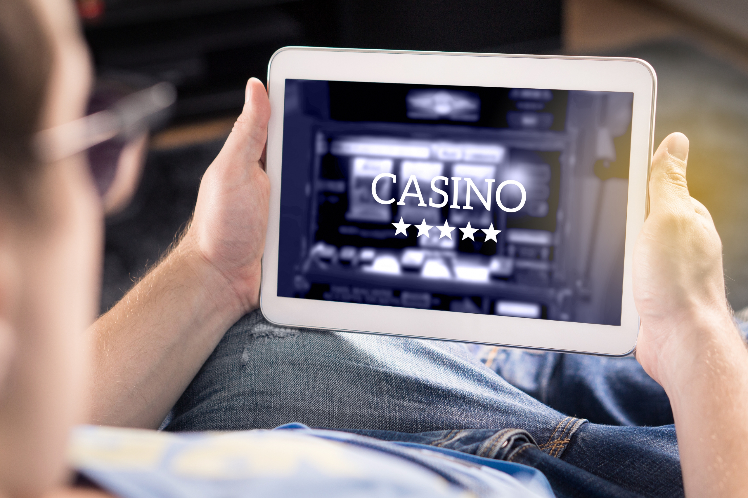 Man playing in an online casino with tablet. Modern gambling application.